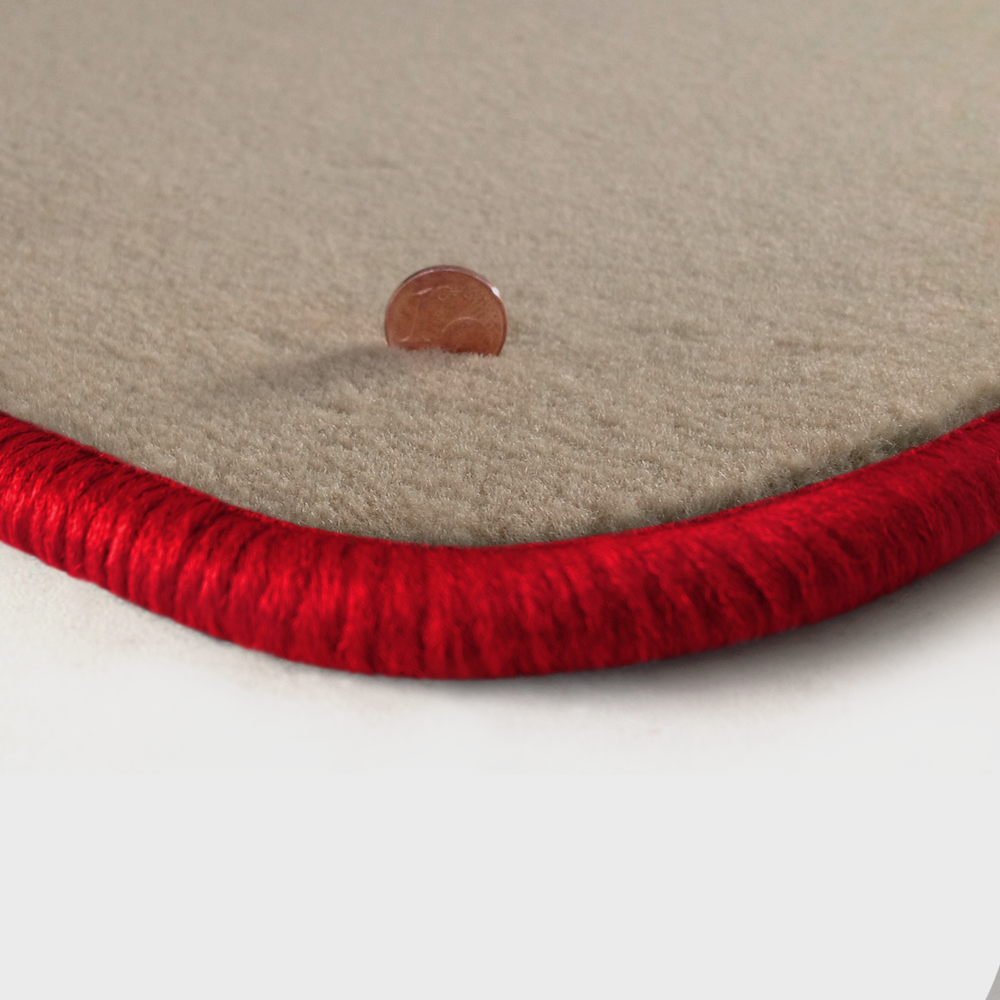 Eine Ecke als Beispiel einer Fussmatte Velours beige mit Rand in rot.