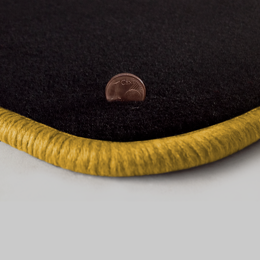 Eine Ecke als Beispiel einer Fussmatte Velours schwarz mit Rand in gelb.